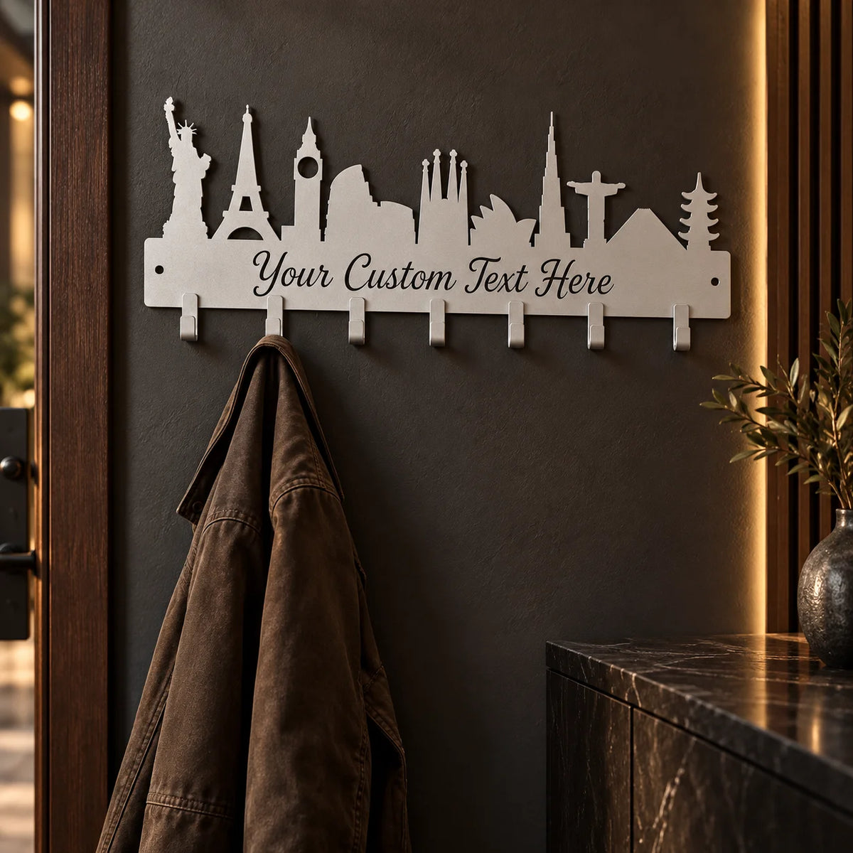 Custom skyline metal coat rack – Silver on a dark wall holding a jacket