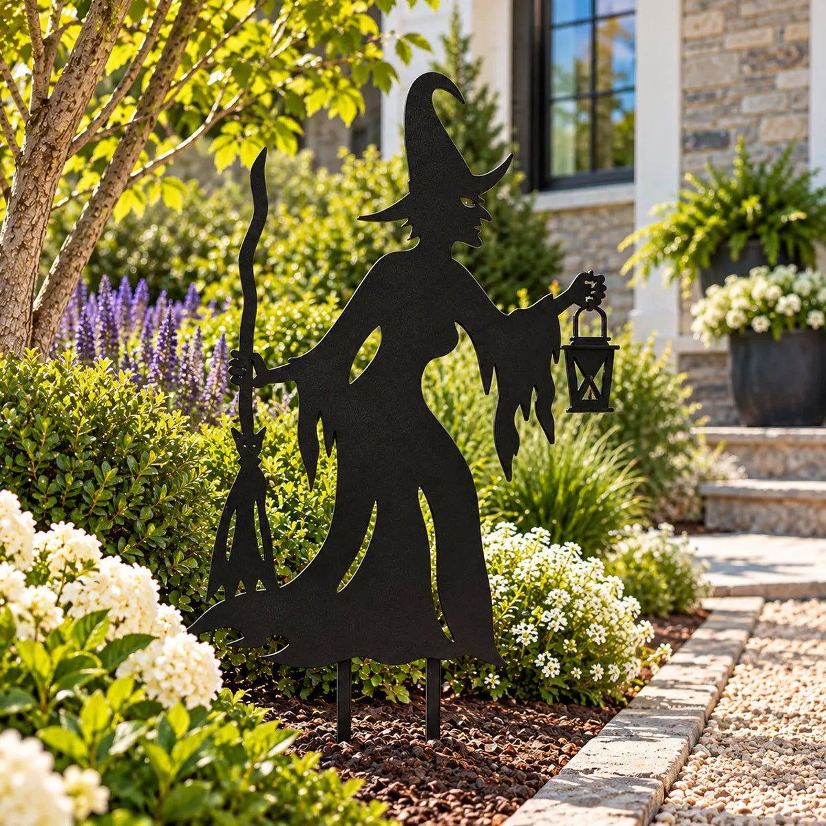Witch metal garden stake – Black in a sunny front-yard flower bed